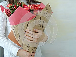 Young girl, teen girl holding bouquet of pink, red roses.