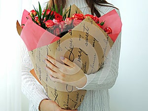 Young girl, teen girl holding bouquet of pink, red roses.