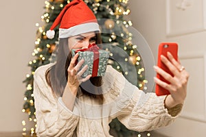 The young girl telephone to parents and show a green red Christmas gift