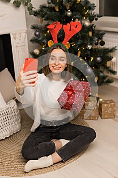 The young girl telephone to parents and show a red Christmas gift