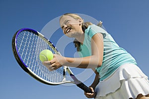 Young girl on tennis court Preparing to Serve low angle view close up