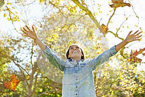 Young Girl Throwing Autumn Leaves In The Air