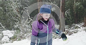 Young girl throws a snowball then claps with delight