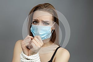Young girl with tied hands in a medical mask