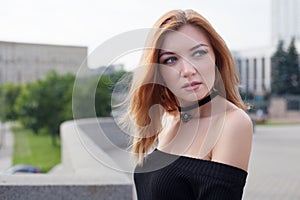 A young girl in a tight black dress is walking in the city