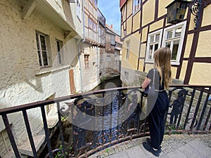 A young girl tourist admiring Quedlinburg narrow canal in the Old Town