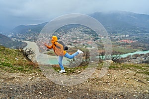 Young girl tourist rejoices posing against the backdrop of an amazing natural landscape. The confluence of two rivers in the city