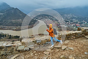 Young girl tourist rejoices posing against the backdrop of an amazing natural landscape. The confluence of two rivers in the city