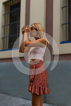 Young girl tourist in Seville, taking a picture with his camera.