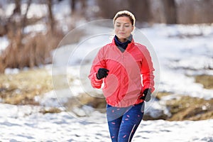 Young girl on trail running training in winter