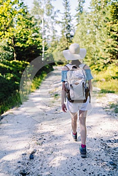 Young girl traveler with backpack while hiking