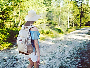 Young girl traveler with backpack while hiking