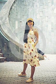 Young girl traveler sitting on circle stairs of a spiral staircase of an underground crossing in tunnel at Fort Canning Park, Sin