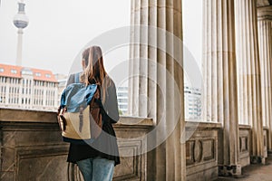 A young girl traveler or tourist or student with a backpack travels to Berdlin in Germany