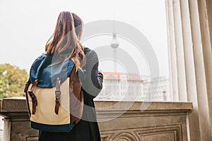 A young girl traveler or tourist or student with a backpack travels to Berdlin in Germany