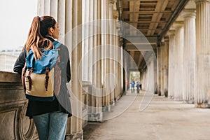 A young girl traveler or tourist or student with a backpack travels to Berdlin in Germany