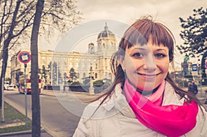 Young girl traveler with white jacket and red scarf looking at camera and smile, Kunsthistorisches Museum