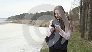 young girl is traveling tourist listens to music on his phone in nature