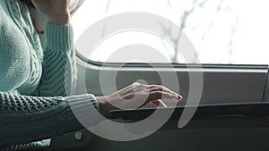 Young girl travelling in a train and using notebook. Female hands using touchpad of laptop pc. Girl chatting with