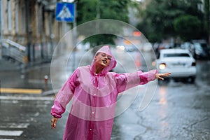 Young girl trying to stop a cab. Woman calling a taxi on a rainy day.