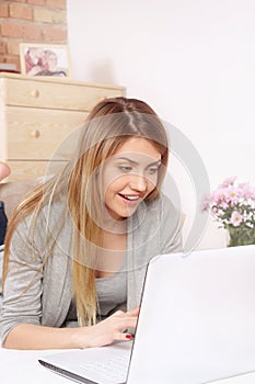 Young girl typing on laptop at home