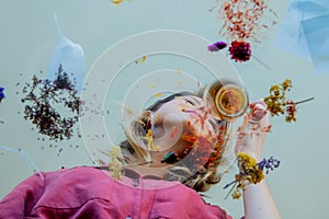 Young girl from under glass table while she prepares leaves before brew a tea