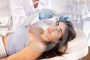 Young girl undergoing skin therapy session with application of atomized nutrients