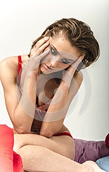 Young girl in underwear in bed crying and wiping tears smearing her hands