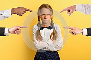 Young girl is unhappy and angry because she is accused. yellow background