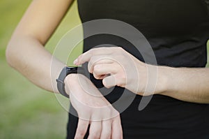 A young girl uses a fitness tracker. Smartwatch.