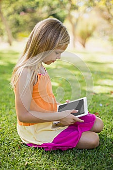 Young girl using digital tablet in park