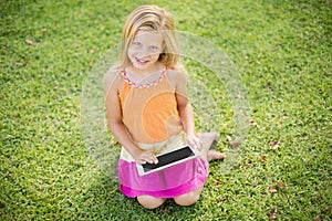 Young girl using digital tablet in park