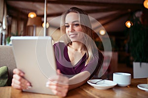 Young girl using 4g on tablet in cafe. photo