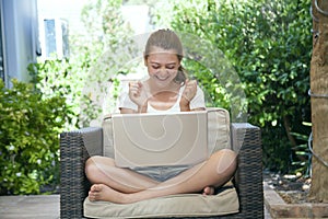 A young girl using her laptop outside