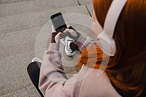 Young girl using mobile phone while sitting outdoors