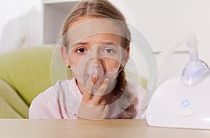 Young girl using a nebulizer inhaler device with mist shooting out of the mouthpiece