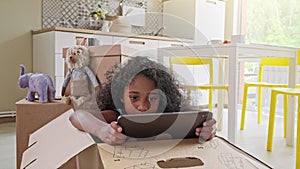 Young girl using tablet computer at kitchen table, front view