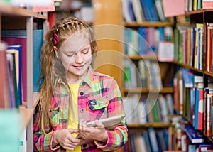 Young girl using a tablet computer in a library