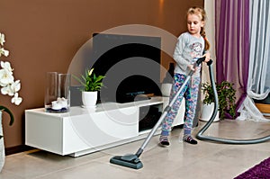 Young girl vacuuming room