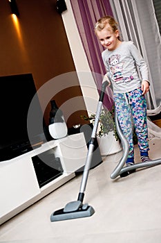 Young girl vacuuming room