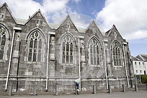 A young girl vaulting bollards outside an abbey photo