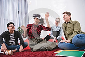 young girl in virtual reality glasses sitting on carpet
