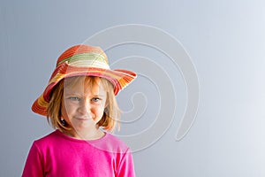 Young girl in vivid pink dress and straw hat