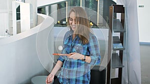 Young girl in the waiting room fooling around with a tennis racket.