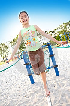 Young girl walking on balancing beam