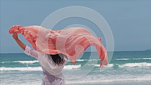 Young Girl Walking on the Beach, Running to the Sea Holding a Paladin. Concept of travel, sea waves, rest on the sea in