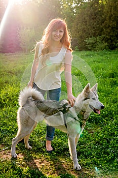 A young girl walking a dog in the park