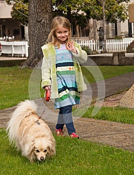 Young girl walking with little dog on a leash