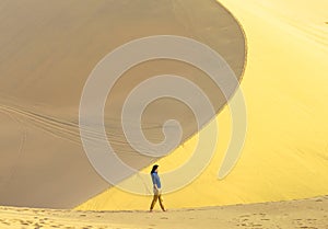 Young girl walks the edge of dune