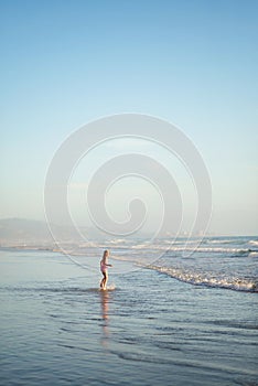 A young girl walks through shallow water